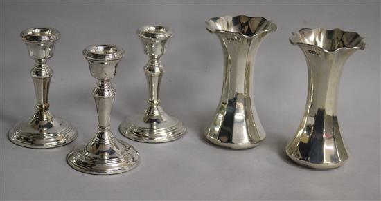 A pair of George V silver spill vases, London, 1911 and a set of three later silver dwarf candlesticks.